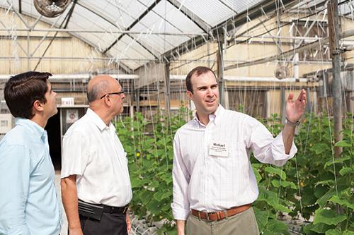Photo of Michael Strahan showing a greenhouse to clients