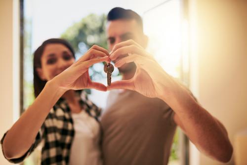 Portrait of a young couple holding the keys to their new home