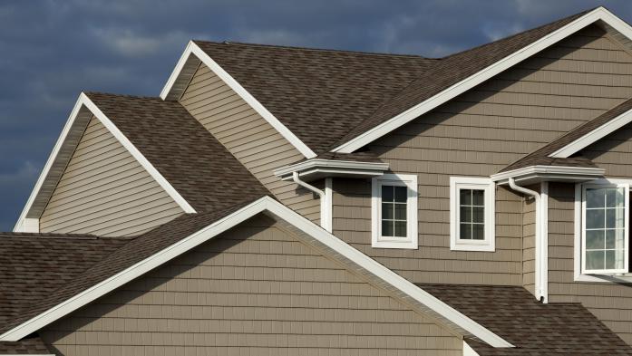 New roof shingles applied to a brown house