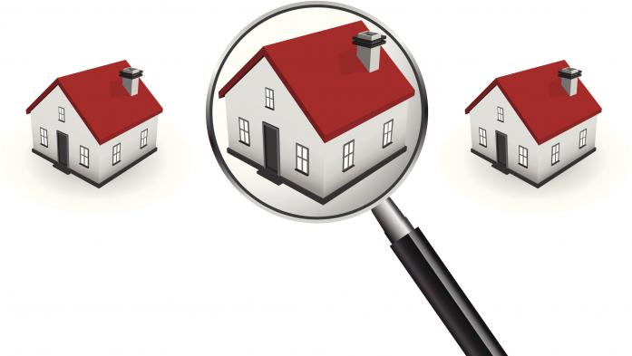 magnifying glass over middle of 3 houses with red roofs