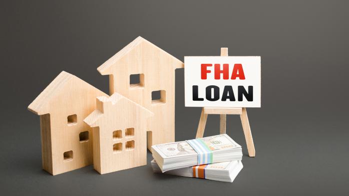 3 wooden homes, a pile of money and an FHA loan sign