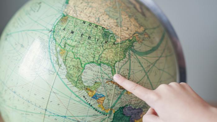 Finger pointing to Florida on a globe of the world