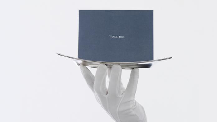 image of a white gloved hand holding a silver platter