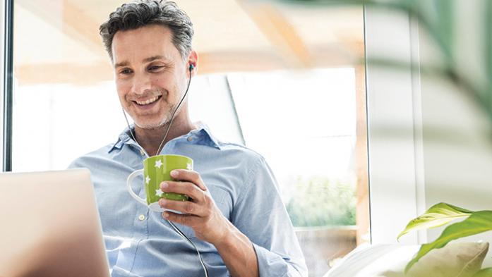 Man with headphones on listening to a podcast
