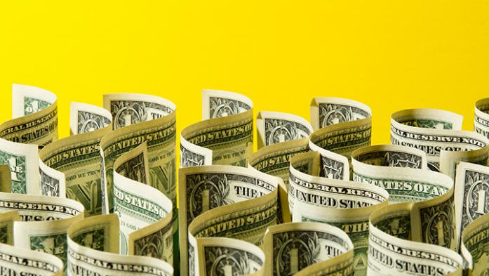 Photo illustration of dollar bills in a wavy pattern on a yellow background
