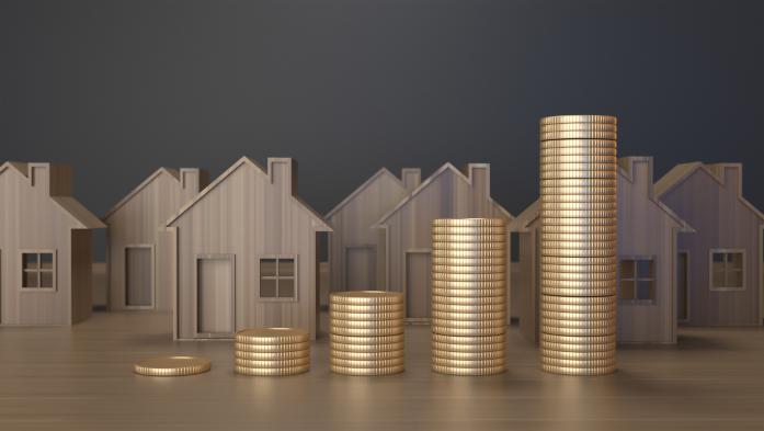 small wooden block houses with stacks of gold coins in front