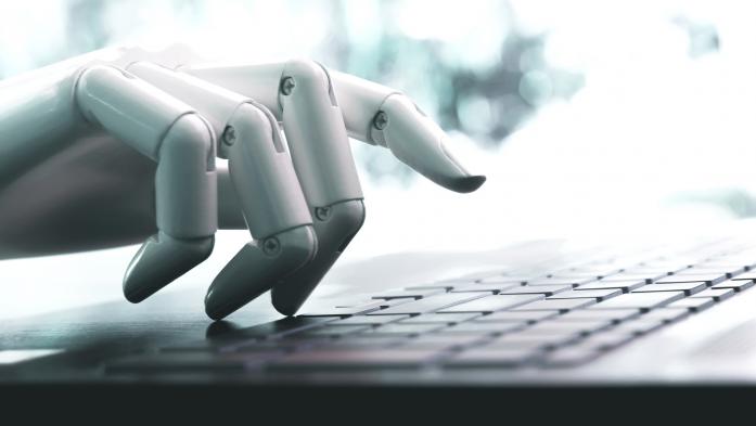 Robotic hands typing on a computer keyboard