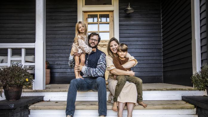 Couple with two young children sitting on front porch