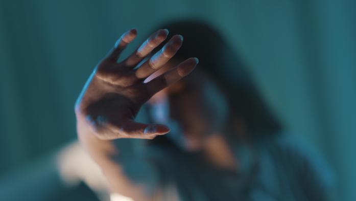 woman in shadow doing stop sign with her hand