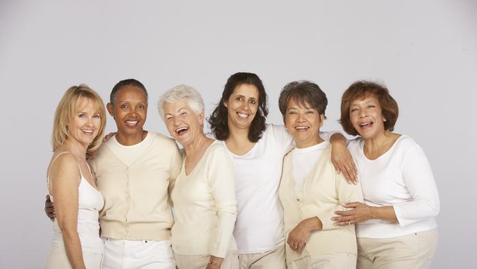 Six happy women of all ages dressed in shades of white