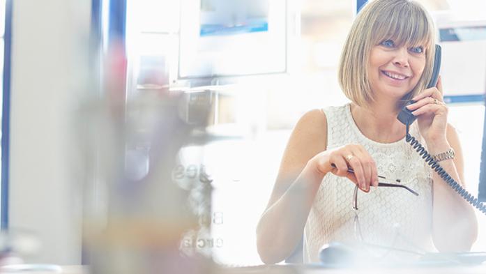 Photo of a female realtor at her desk on the phone
