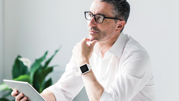 Photo of a business man thinking with tablet in hand