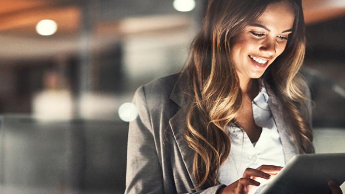 Photo of a business using a tablet and smiling