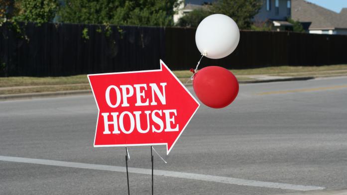red arrow sign with open house in white lettering plus red and white balloons