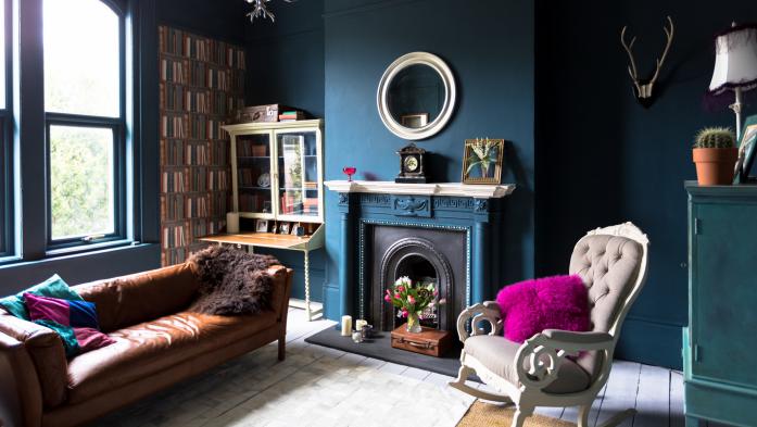 Living room with a pink pillow, blue walls and other offbeat furnishings