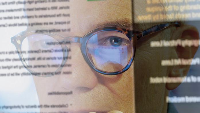 Photo of a man looking at a computer screen with words on it