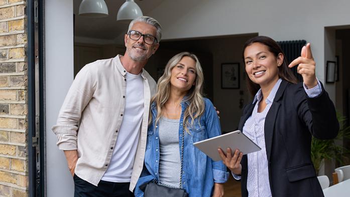Photo of a realtor showing a property to a couple