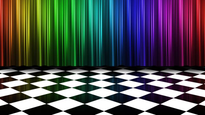 A rainbow colored curtain behind a floor of black and white checkerboard tiles