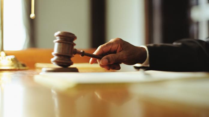 hand with gavel on desk