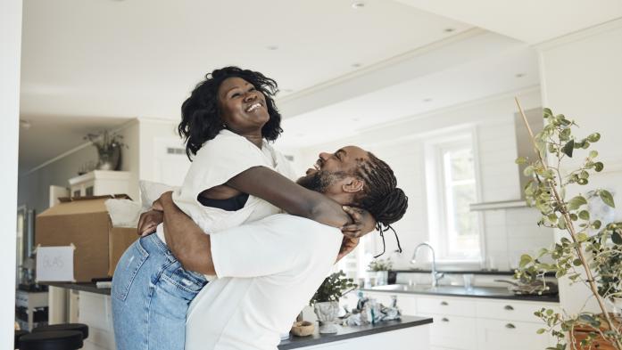 Man lifting woman in air happily in their new house
