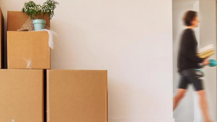 women walking past doorway and moving boxes