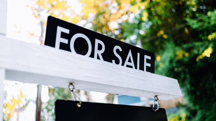 For Sale Sign in Front Yard of House - stock photo  Close-up of for sale rider on real estate sign post in front yard of house