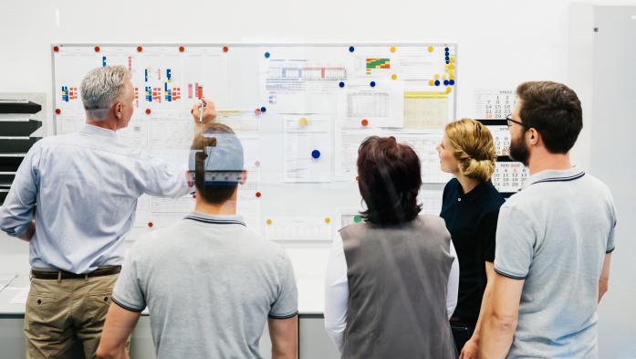 Group of people looking at planning on a board