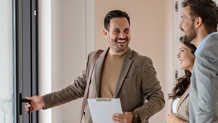 Male real estate agent showing a couple a house