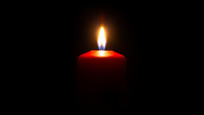 small red candle lit with a black background