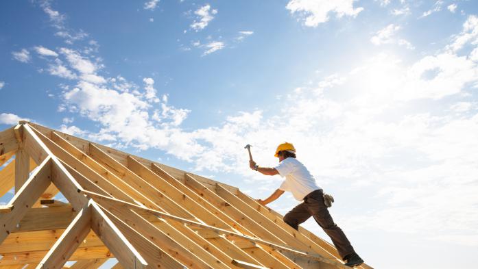 construction worker hammering on a roof