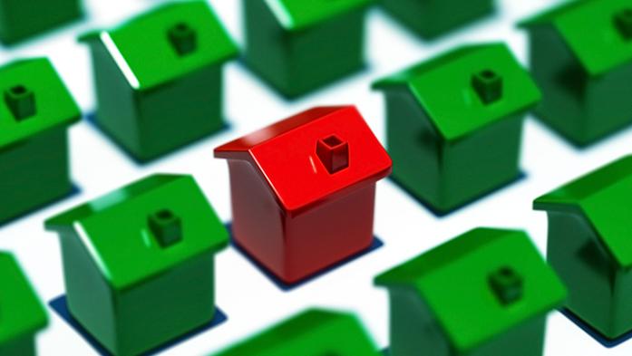 photo of many green toy houses with one highlighted in red