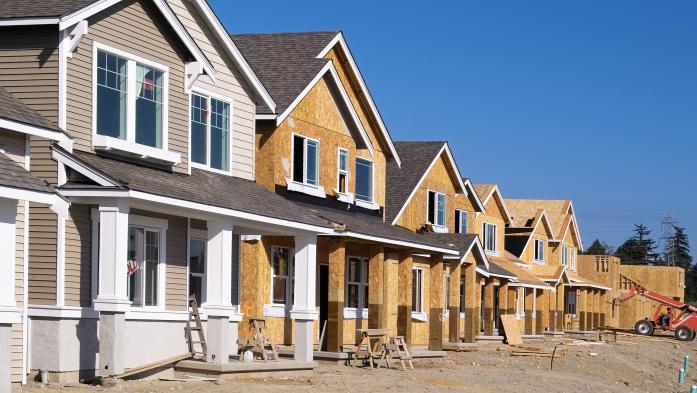 Housing Development Under Construction - stock photo  Perspective photo of a row of similar style houses during various phases of construction.