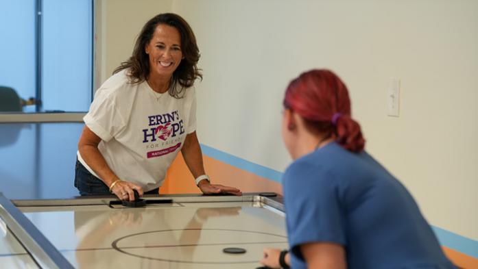 Stacy Horst plays table hock with a young adult 