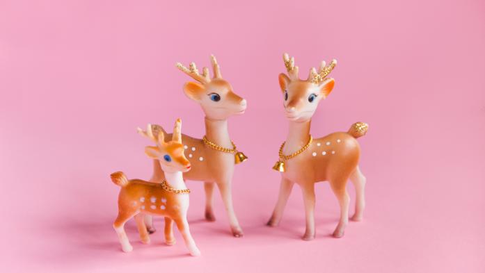 Pink Christmas Background with Vintage Reindeer Family - stock photo  Vintage Christmas background, conceptual family, no people. Plastic reindeer family Christmas decorations on pink background. Conceptual image for mother and father, family with one child, and family themes. Copy space.