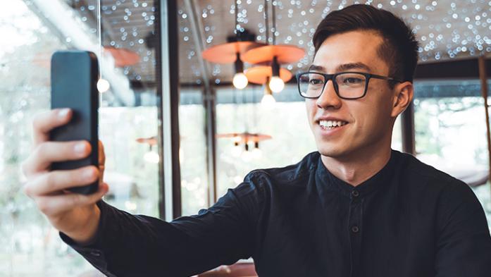 Photo of a man taking video with his phone