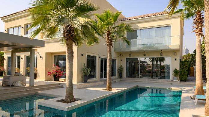 Luxury villa with palm trees and swimming pool. Exterior of modern house. Empty back area of house