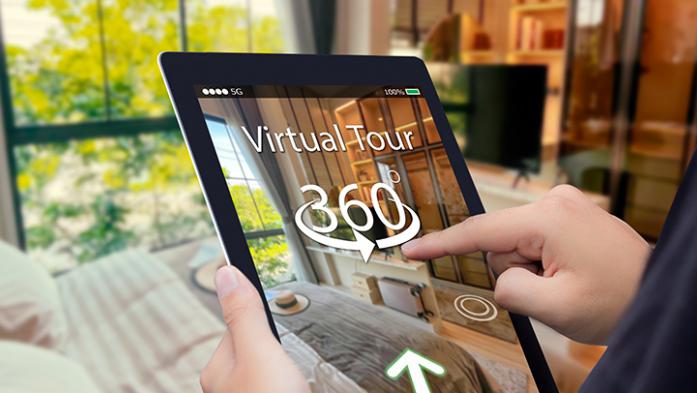 Photo of a person holding a tablet with a virtual tour of a home on the tablet