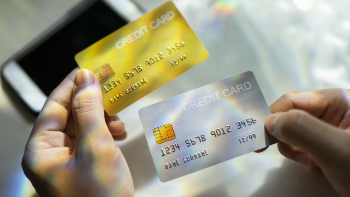 Close up Hand holding Blank credit card black,gold,platinum color with spectrum light and shadow background
