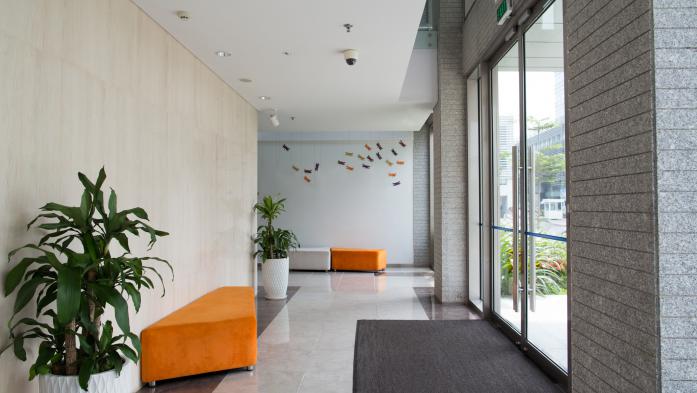 Empty entrance of condominium building. Glass doors and hall of hotel building. Living space concept