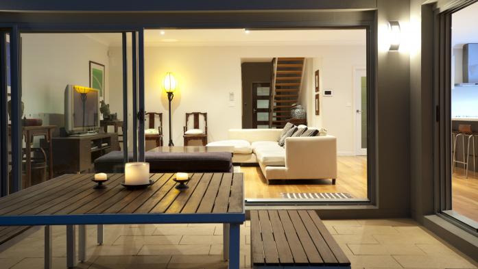 Indoor-outdoor living space with couch in living room and table on patio