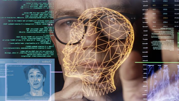 Close up stock image. Looking through a touch screen display to a man’s face. He’s studying imagery depicting AI (artificial intelligence) avatars, chatbots & associated coding.