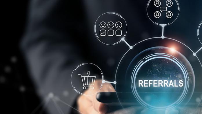 photo illustration of a person holding a table with the word Referrals on top and icons of multiple people connecting
