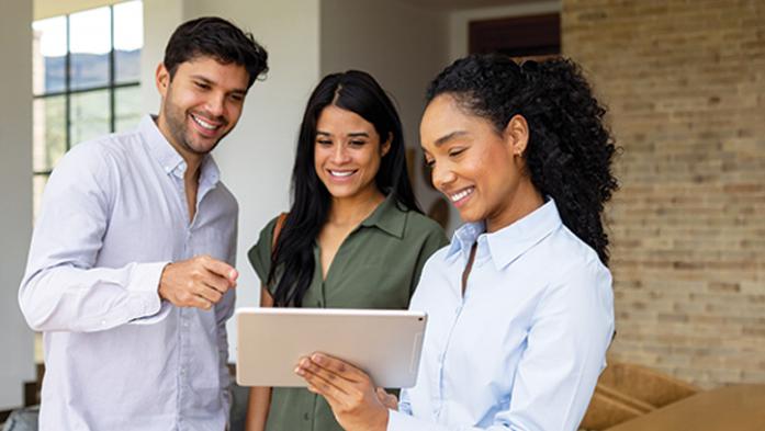 Photo of real estate agent with clients looking at buyer agreement