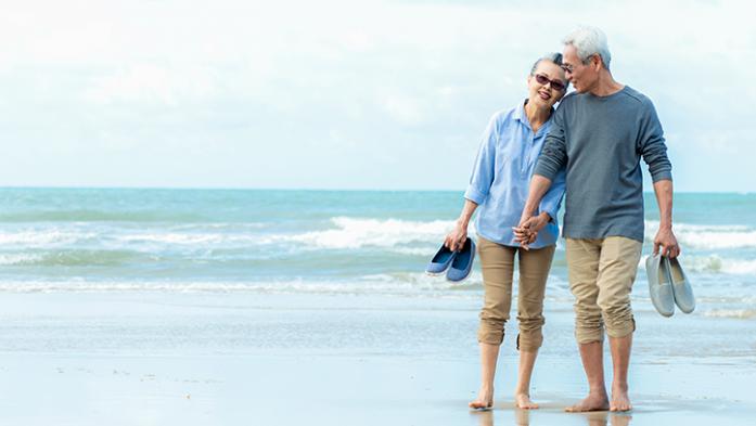 photo of a retired asian couple on the beach