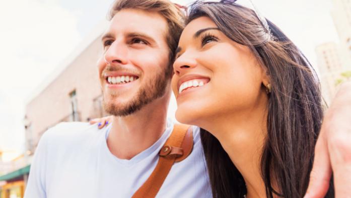 Smiling couple outdoors looking up