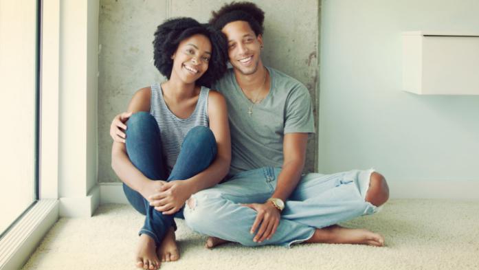 Happy couple sitting on floor of new home