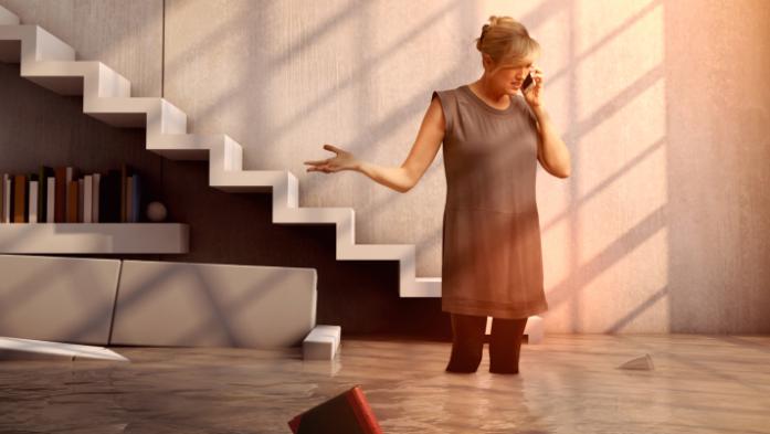 woman on phone in flooded home