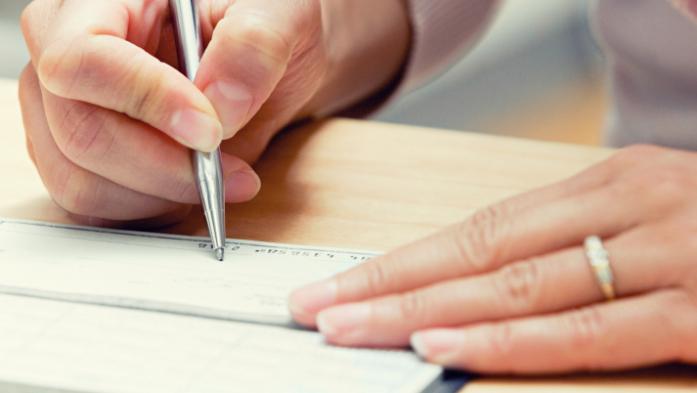 woman's hands writing a check