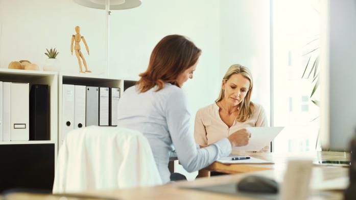 women looking at paperwork filling out forms