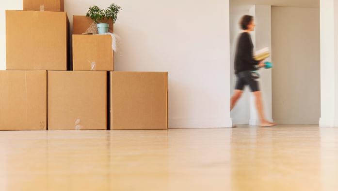 woman walking past doorway and moving boxes 